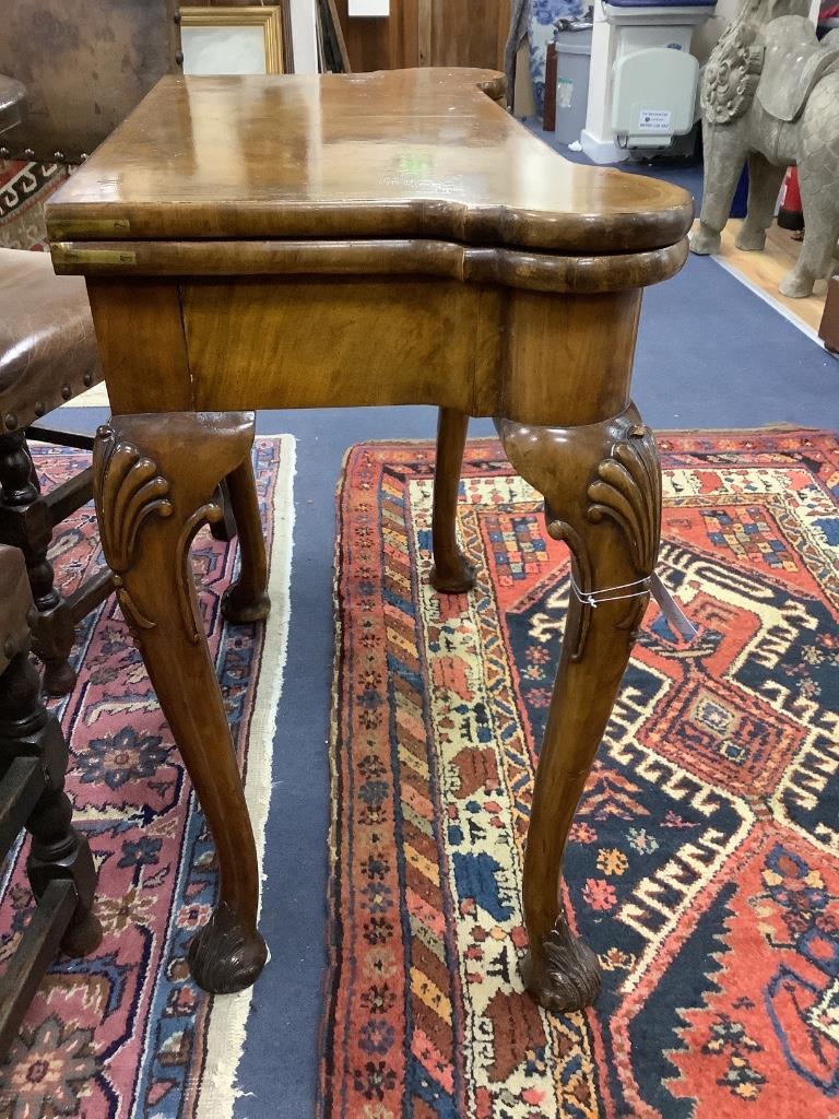 A Queen Anne revival walnut concertina folding card table, stamped Gill and Reigate, London retailed by S & H Jewell, width 81cm, depth 40cm, height 75cm